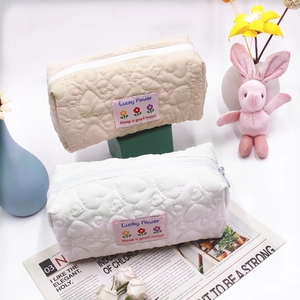 Detailed heart-quilted texture on cream and white floral stationery storage bags