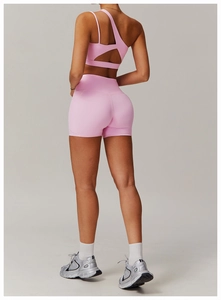 Detail view of pink one-shoulder yoga bra and high-waisted shorts with irregular back straps