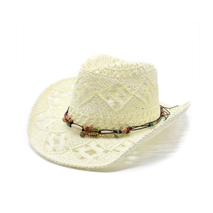 Dettaglio cappello cowboy in paglia intrecciata con perline colorate e ciondoli in metallo
