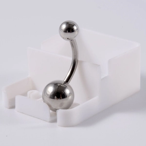 Vue macro d'un piercing de nombril en acier inoxydable argenté avec double boule polie