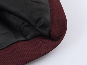 Close-up of burgundy knit fabric and black lining on a vintage style short jacket