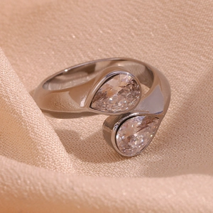 Macro shot of silver-tone open ring featuring two teardrop zircon stones on a soft fabric