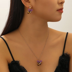 Detail von Football-Anhänger mit lila Schleife und glitzernden Herzohrringen am Modell