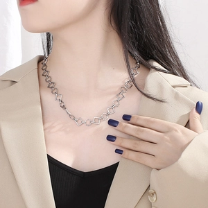 Handmade stainless steel necklace with geometric links worn by a professional model