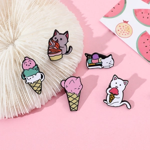 Set of five cartoon cat and ice cream enamel pins displayed on a pink background