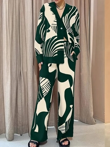 Détail du motif abstrait vert et beige sur l'ensemble chemise et pantalon en satin soyeux