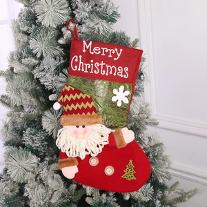 Close-up of red and green Christmas stockings with plush Santa dolls and embroidery
