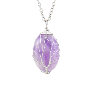 Macro detail of natural amethyst tree of life pendant with silver wire wrap and chain