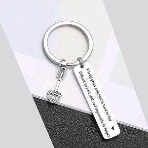 Macro shot of stainless steel keychain with heart arrow charm and engraved silver plate
