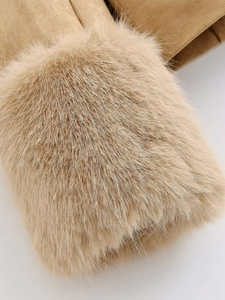 Macro shot of plush faux fur cuffs and soft suede texture on beige winter gloves