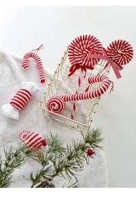 Detail of red and white velvet candy and cane ornaments in a metal basket