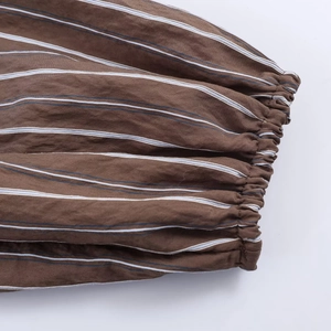 Detailaufnahme von braunen elastischen Rippbündchen mit weißen und blauen Streifen