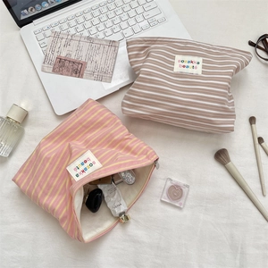 Detail of striped cotton cosmetic bags in pink and brown with inner lining storage