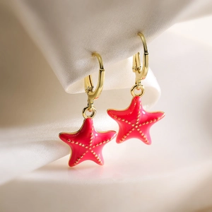 Detail of pink enamel starfish drop earrings on white silk with 18K gold plated hoop