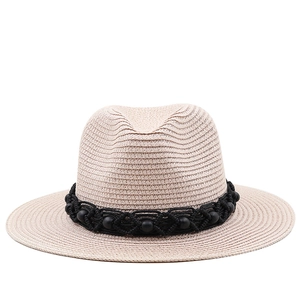 Detailed macro view of beige straw fedora featuring a woven black beaded decorative band