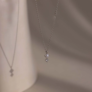 Detailed close-up of a silver titanium steel necklace with small pearl and zircon accents