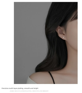 Close-up of elegant S925 silver stud earring with white zircon on model's ear