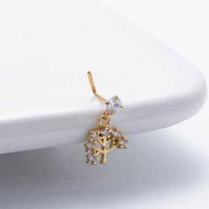 Macro shot of gold nose stud with a sparkling zircon Tree of Life pendant detail