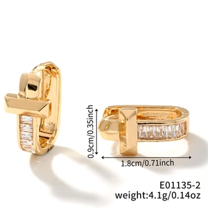 Detail view of gold U-shaped earrings with T-bar and baguette-cut cubic zirconia stones