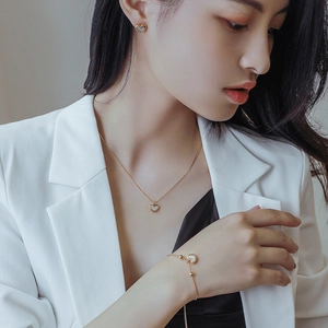 Elegant gold heart jewelry set featuring shell pendant necklace and matching earrings