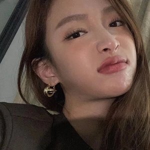 Elegant gold twisted hoop earring shown on ear in a minimalist planet-inspired hollow design
