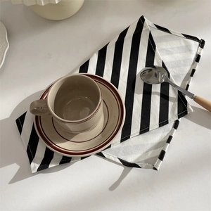 Minimalist black and white striped placemat with ceramic coffee cup in Nordic style