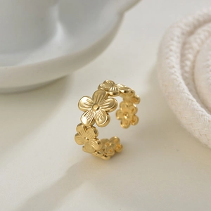 Macro shot of gold-plated open ring with detailed 3D floral daisy embossed pattern