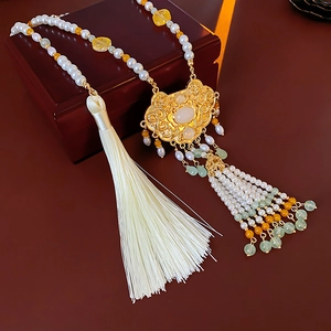 Detail of gold longevity lock pendant with pearls and a long white silk tassel