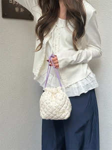 Detail of white floral quilted drawstring bag with lavender small flower pattern