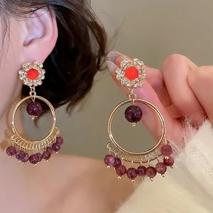 Vintage gold earrings with red stones, purple beads, and bohemian tassel accents
