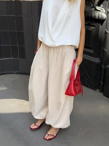 Detail of off-white cotton harem pants featuring an elastic waist and street style silhouette