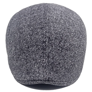 Detail of grey herringbone fabric texture on a vintage wool blend flat cap for men