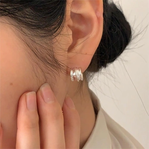 Minimalist 925 sterling silver triple wave stud earrings shown worn on the earlobe