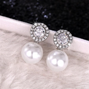 Macro detail of luxury pearl earrings with sparkling micro-pave cubic zirconia accents