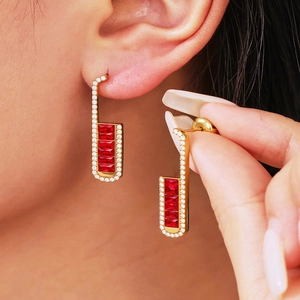 Elegant gold U-shaped earrings with red baguette-cut stones and white zircon details