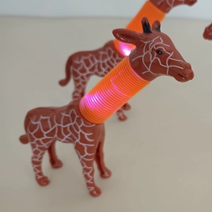 Close-up of giraffe telescopic pop tubes with glowing LED light in a soft orange hue