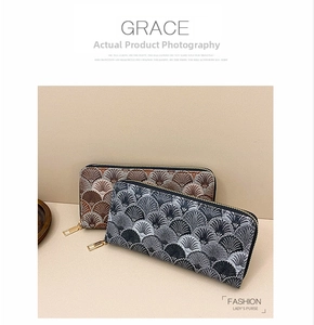 Detail of long wallets with scalloped texture embroidery and golden metal zippers