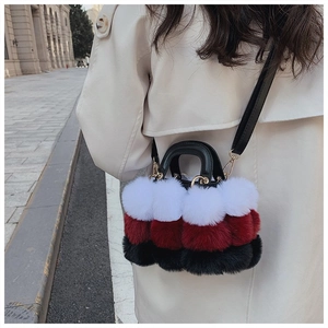 Detail of plush faux fur handbag with white, burgundy, and black striped stitching texture