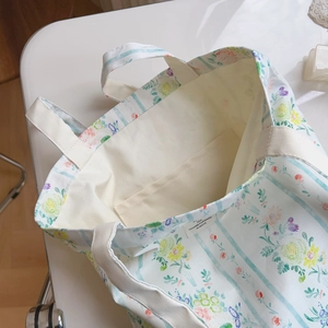 Dettaglio della borsa tote in cotone floreale con tasca interna e cuciture rifinite