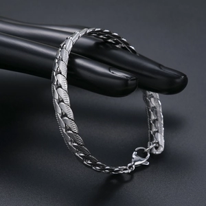 Polished silver stainless steel cuban link bracelet for men displayed on black model hand
