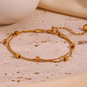 Detail of 18K gold plated double-layer snake chain bracelet with square bead accents