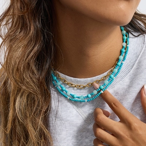 Layered 18K gold stainless steel necklace with turquoise and white pearl beads on model