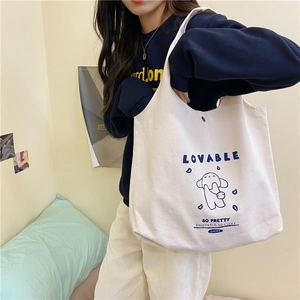 Détail du sac cabas en toile avec imprimé chien mignon et fermeture à bouton pression