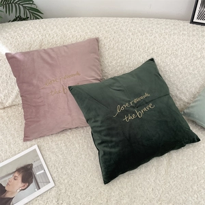 Close-up of velvet pillow covers with gold embroidery and soft texture details