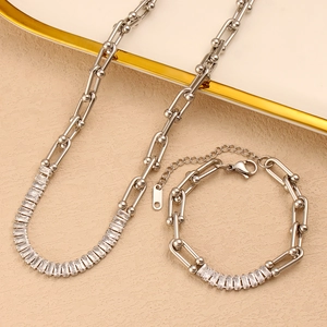 Close-up of silver U-shape chain necklace and bracelet set with rectangle zircons