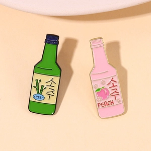Cute green and pink enamel pins shaped like soju bottles with fresh peach and bamboo motifs