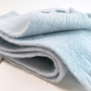Close-up of soft mohair texture in light blue showing the fluffy fiber details and fabric