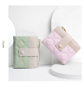 Detail of short quilted wallets in pastel green and pink with snap button closure
