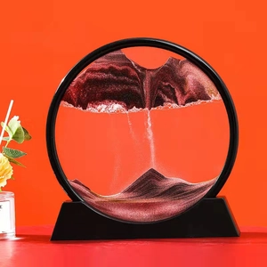 Close-up of circular sand art with red and black flowing landscapes on red background