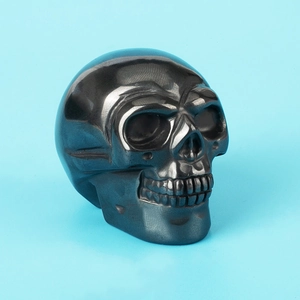 Macro view of a polished black hematite crystal skull carving with a metallic luster